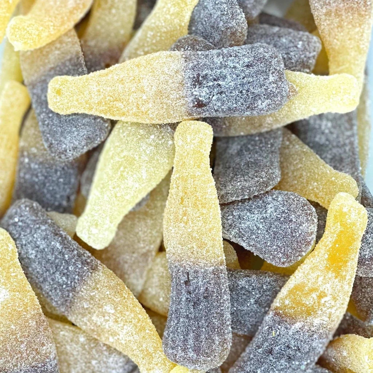 Close-up of gummy bottled candies with a gradient colour effect.