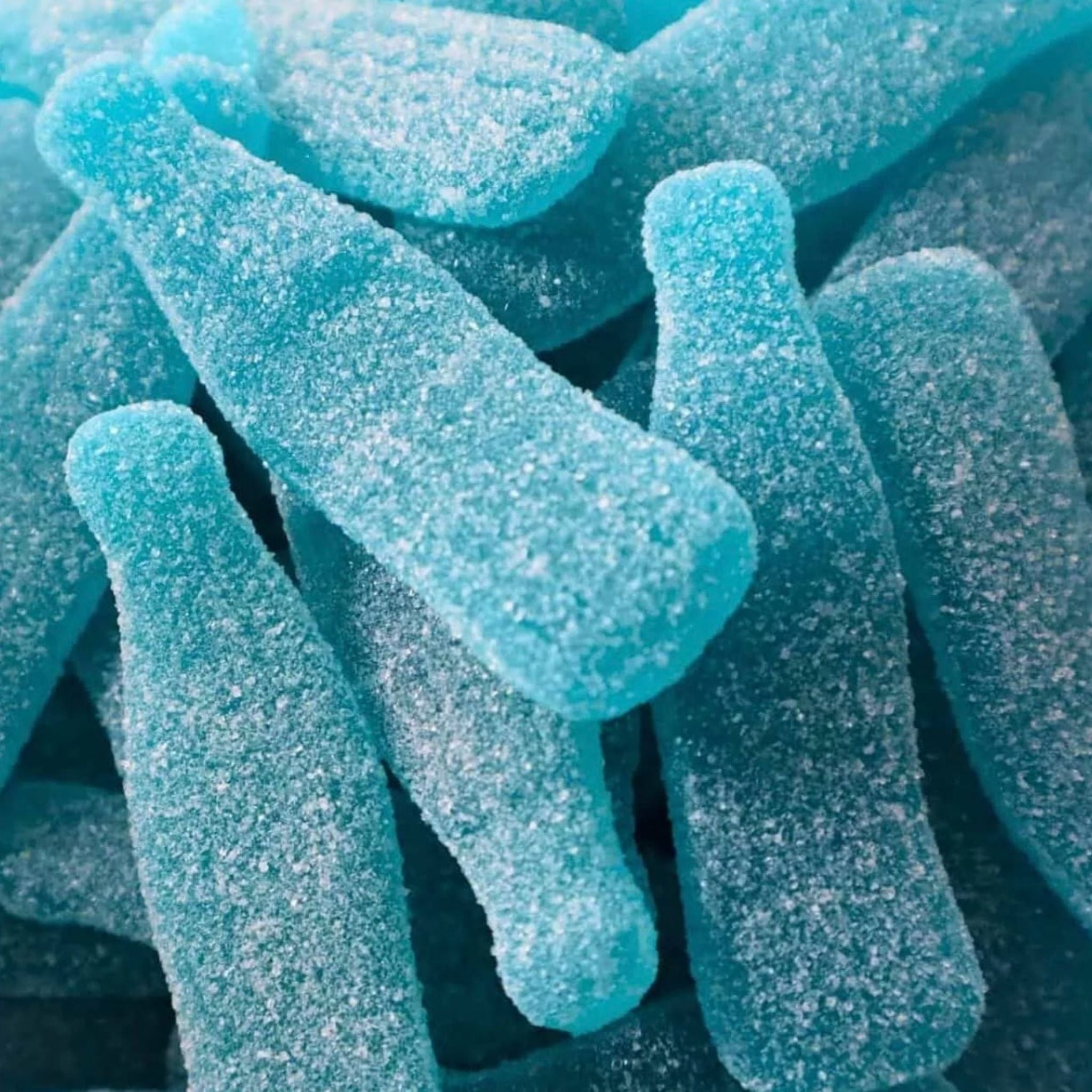 Close-up of blue gummy bottles with a sugary texture.